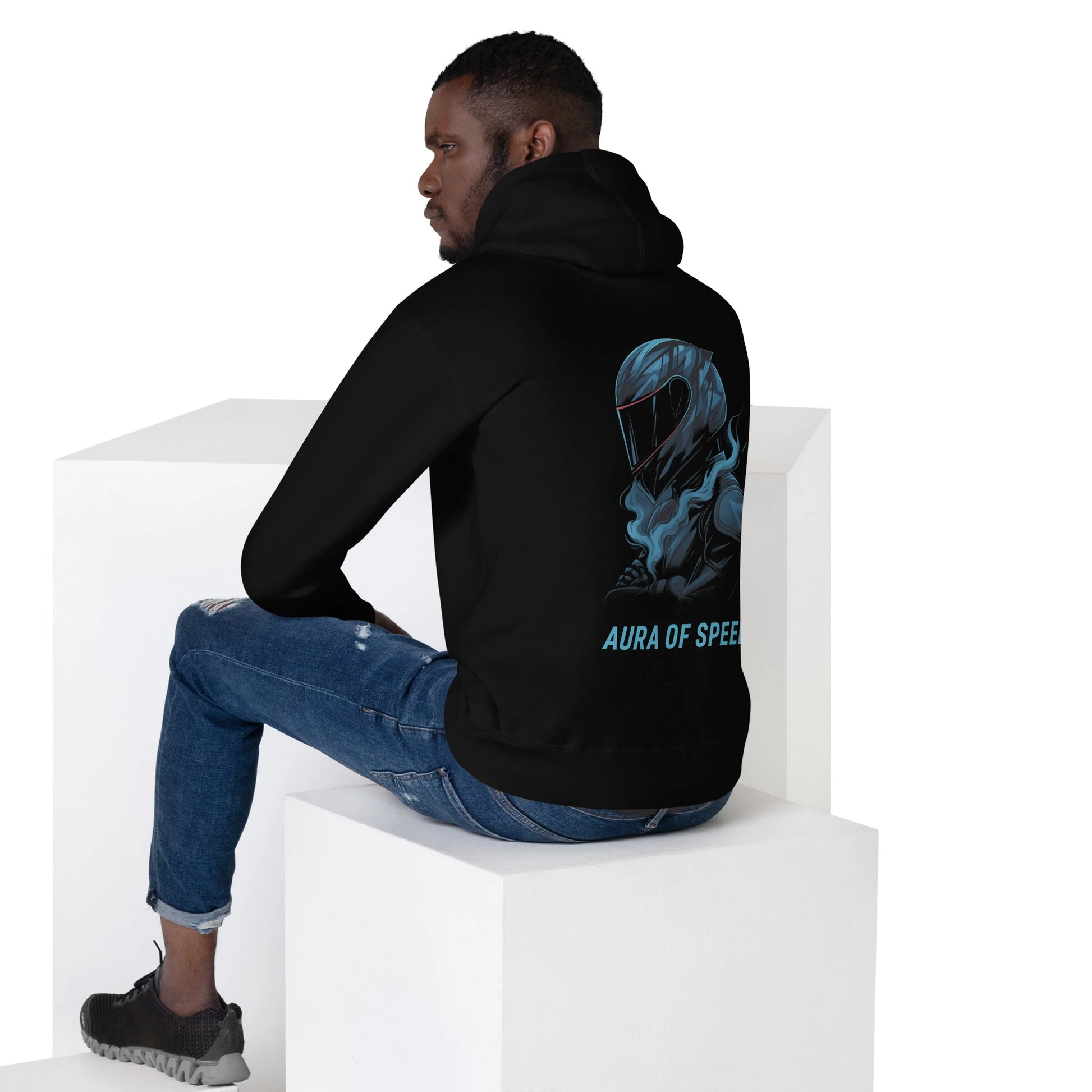 Man wearing black hoodie with blue motorcycle helmet graphic and 'Aura of Speed' text on the back.