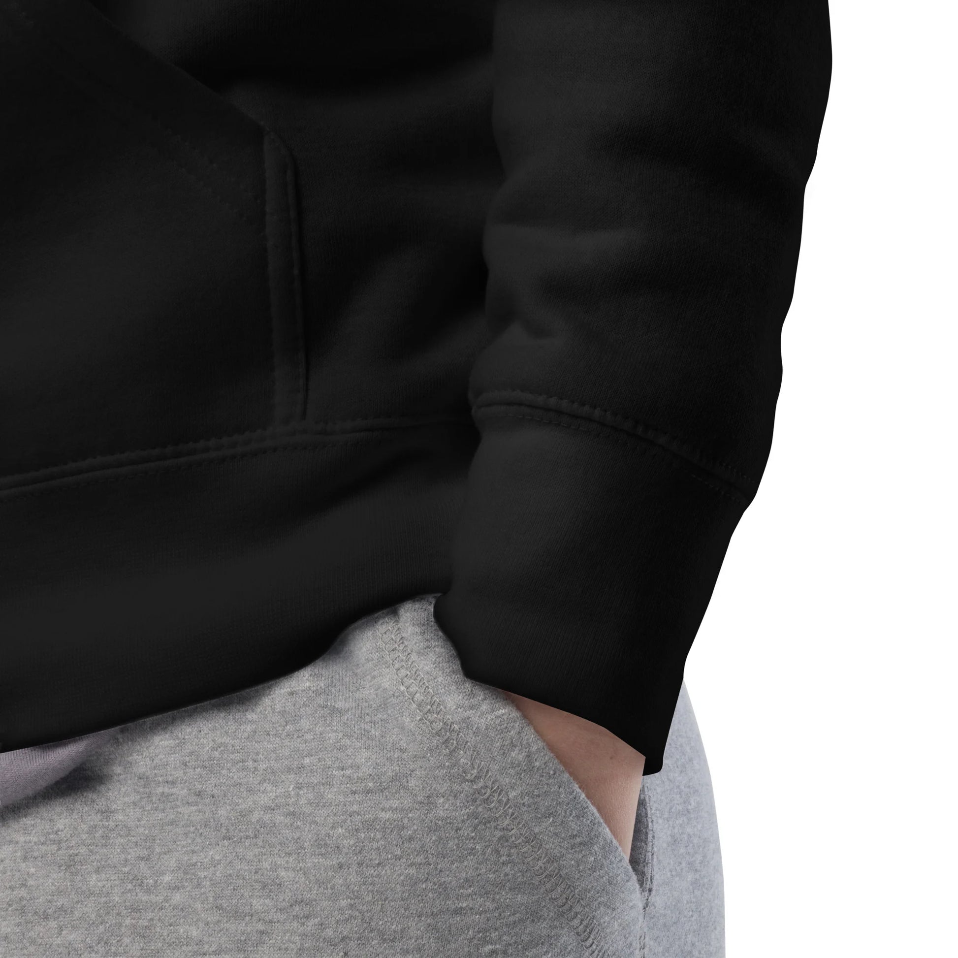 Close-up of black hoodie sleeve and cuff showing stitching and premium fabric texture.