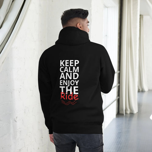 Man wearing black hoodie with bold white and red vertical 'Keep Calm and Enjoy the Ride' text on the back, standing indoors.
